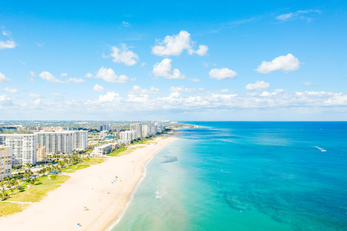 Pompano Beach, Florida homes for sale — Aerial view of the Pompano Beach Florida coastline with white sand, the fishing pier and beachfront condominium towers at sunset